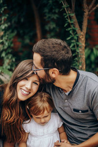 Smiling loving family against trees