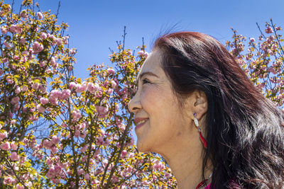 Portrait of beautiful woman against red flowering plants