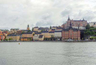 Buildings in city against cloudy sky