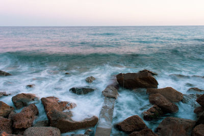 Scenic view of rocks in sea against sky