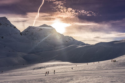 The sun setting behind a mountain, over the slopes of les arcs