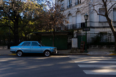 Car on street against buildings in city