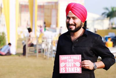 Portrait of smiling young man holding placard