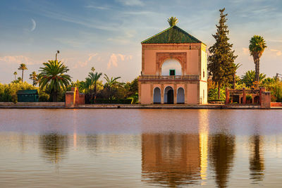 Building by lake against sky