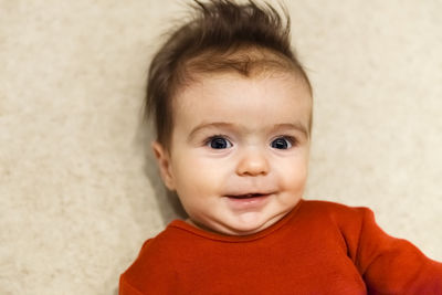 High angle portrait of cute baby girl lying at home