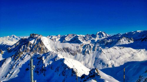 Scenic view of snowcapped mountains against clear blue sky