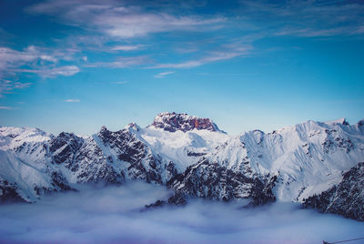 Snow covered mountain against blue sky