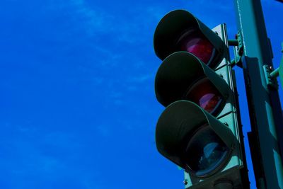 Low angle view of road signal against clear blue sky