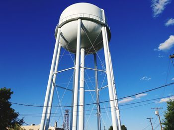 Low angle view of water tower against blue sky