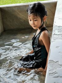 Cute girl looking at woman in water