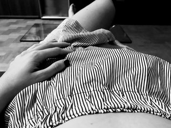 Midsection of woman wearing striped skirt