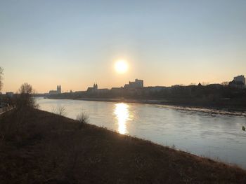 View of city at waterfront during sunset