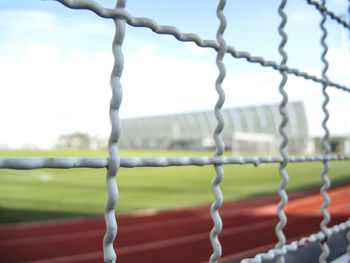 Close-up of metal grate against sky