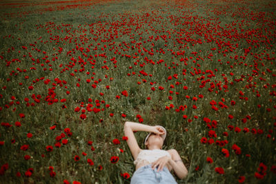 Rear view of woman standing amidst flowers
