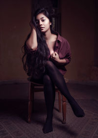 Portrait of beautiful young woman sitting at home