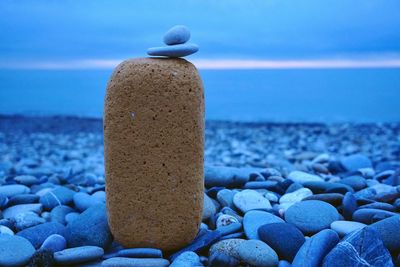 Close-up of pebbles on beach against blue sky