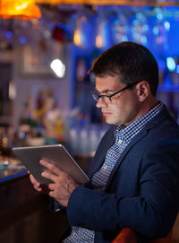 Businessman using digital tablet at bar