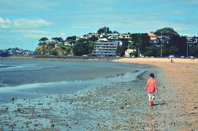 Rear view of a man walking on beach