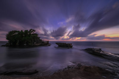 Scenic view of sea against dramatic sky during sunset