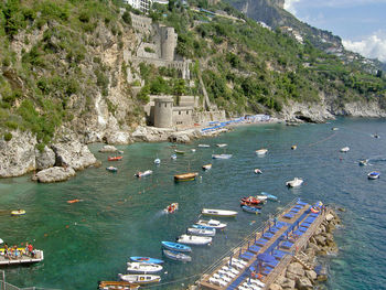 Boats moored in sea against mountain