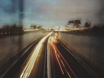 Light trails on road against sky at night