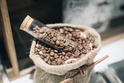 High angle view of raw coffee beans in jar on sack