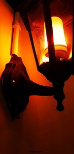 Close-up of illuminated lamp against orange sky