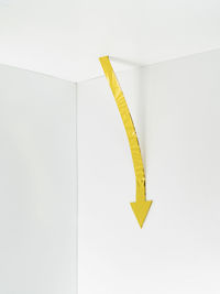 High angle view of yellow sign on white background