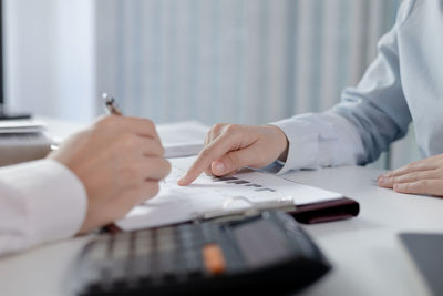 Midsection of business colleagues working on table