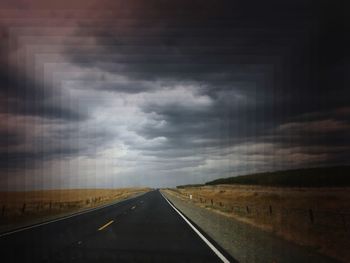 Empty road along countryside landscape