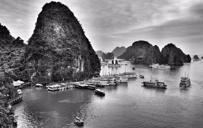 Boats moored at harbor in ha long bay against sky