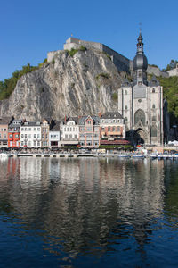 Buildings at waterfront against blue sky