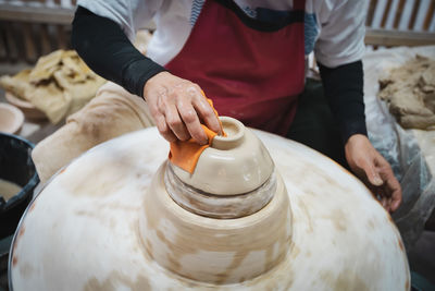 Midsection of potter working at workshop