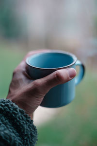 Close-up of hand holding coffee cup