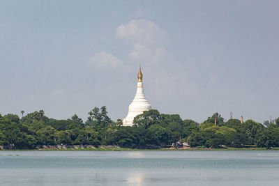 View of temple building by trees against sky