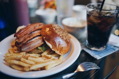 Close-up of hamburger and french fries in plate on table at restaurant