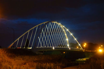 Low angle view of illuminated bridge against sky at night