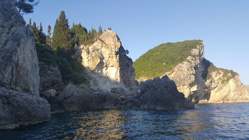 Scenic view of sea and mountains against clear sky