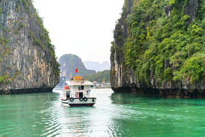 Boat on sea against mountain