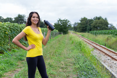 Portrait of young woman standing on railroad track