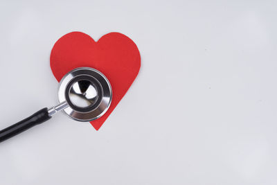 Close-up of red heart shape over white background