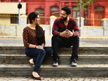 Full length of friends sitting outdoors