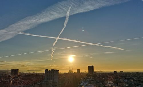 Buildings in city against sky during sunset