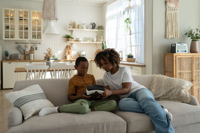 Young woman sitting on sofa at home