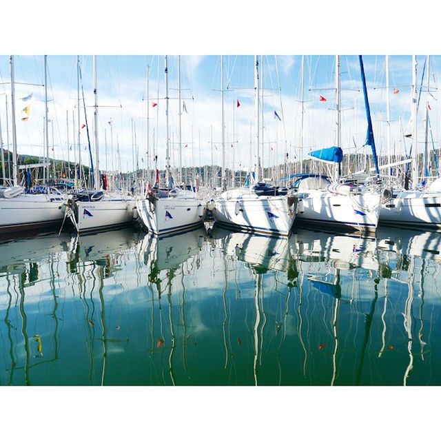 moored, nautical vessel, water, boat, harbor, transportation, reflection, transfer print, mode of transport, group of objects, mast, sea, chair, auto post production filter, sky, day, side by side, sailboat, in a row, large group of objects