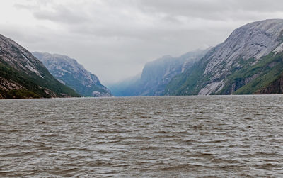 Scenic view of sea and mountains against sky