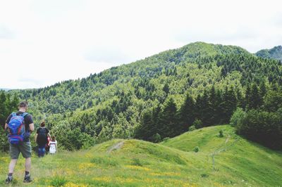 Rear view of people on mountain against sky