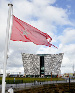 Flag against built structure against sky