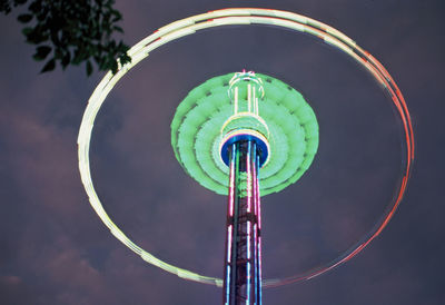 Low angle view of spinning ride at night, just like a illuminated chandelier.