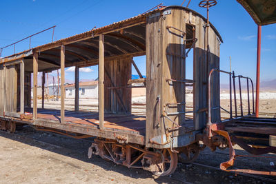 Abandoned train on beach against clear blue sky